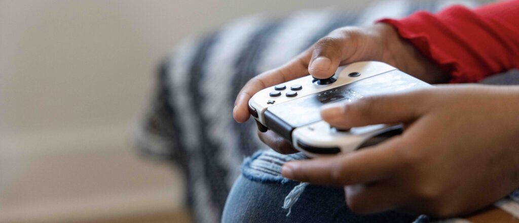 Young person holding a Nintendo Switch controller