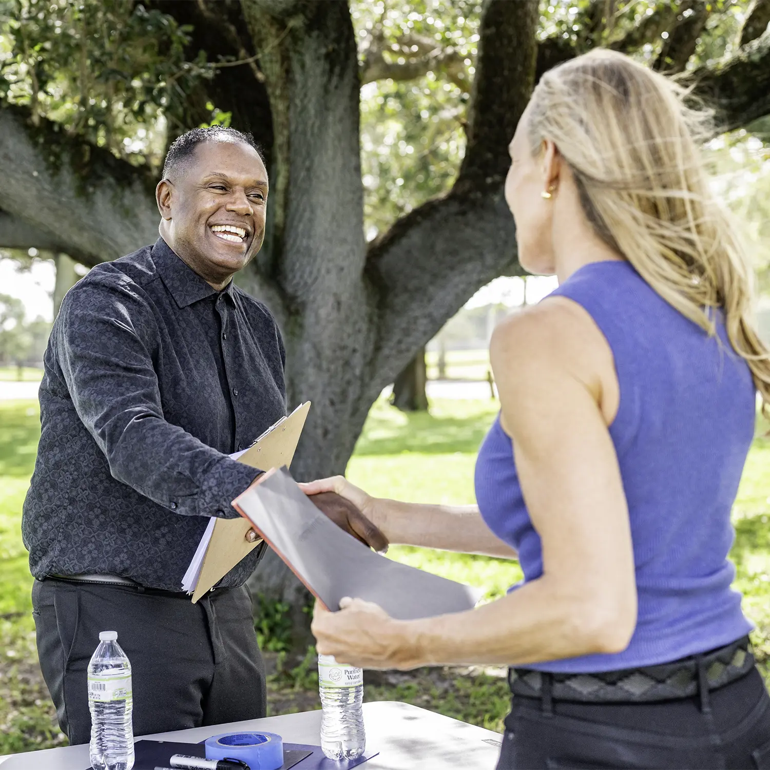 Community members shaking hands at event.