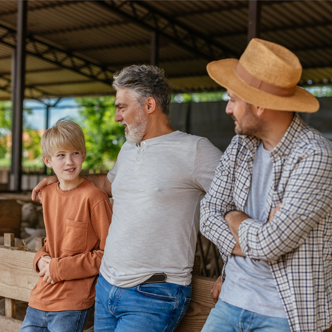 Guys standing in front of farm stable.
